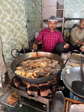 大きな鍋でサモサを揚げている