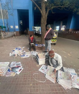 新聞の仕分けをするインド新聞配達員